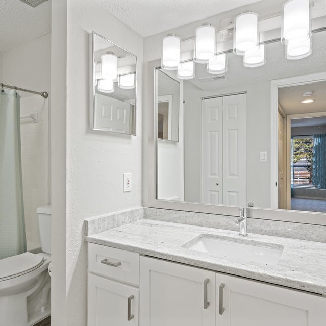 Andover At Crabtree Apartments - Bathroom With Granite Countertops And White Cabinets