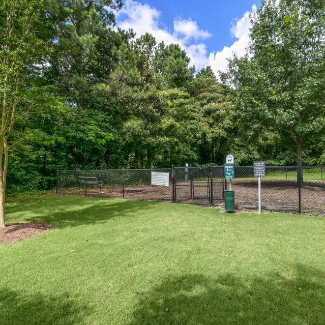 Andover at Crabtree Apartments - gated, grassy dog park