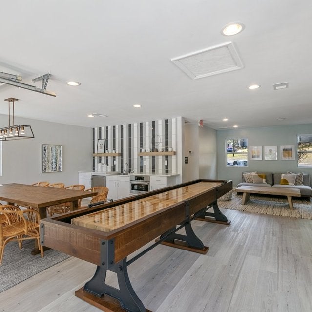 Andover at Crabtree Apartments - clubhouse with dining table, games, and seating area