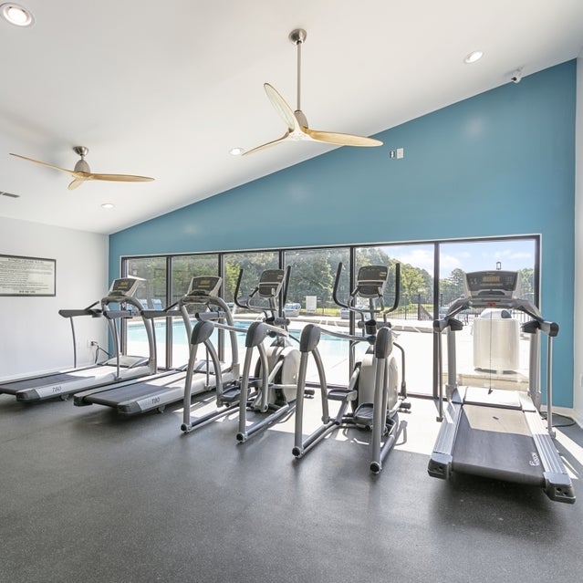 Andover at Crabtree Apartments - fitness center with cardio equipment overlooking pool